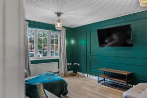 レディングにあるSpacious 5 Bed House in Reading by Amber Stays, Perfect for Business & Contractors, Sleeps 12の緑の部屋(テーブル、テレビ付)