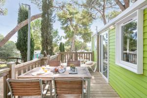 een terras met een tafel en stoelen op een kas bij Càmping Castell Montgrí **** in L'Estartit