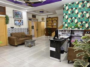 ein Wartezimmer mit einer Couch und einem Tisch in der Unterkunft Royal Executive Residency in Islamabad