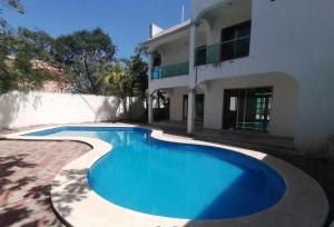 a swimming pool in front of a house at Casa los fundadores 24 7 Security Private Pool Service Included in Playa del Carmen