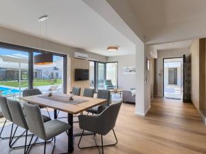a dining room and living room with a table and chairs at Villa Chiara by Interhome in Brtonigla