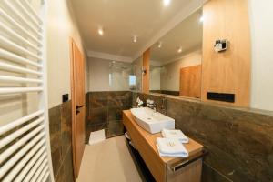 a bathroom with a sink and a mirror at LAMBERT Residences in Lučenec +66 photos