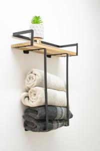 ein Regal mit Handtüchern an einer weißen Wand in der Unterkunft Coqueto apartamento en la playa in Puebla de Farnals