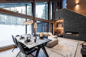 a dining room with a table and a fireplace at Villa Outi, a Luxurious Villa in Äkäslompolo, Lapland in Äkäslompolo