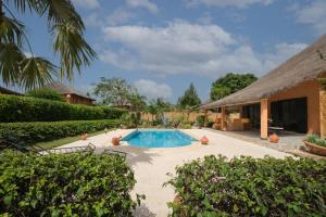 a swimming pool in a yard with a house at Villa Nianing in Nianing