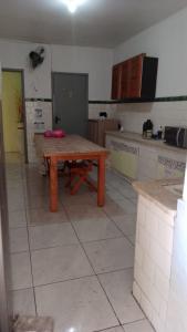 a kitchen with a wooden table in the middle at Hostel Cachoeira in Porto Alegre