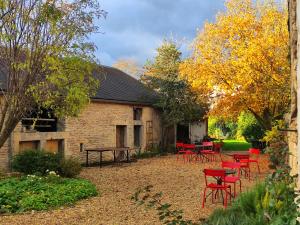 a group of red chairs and a table in a yard at Le 14 Faubourg in Beaune