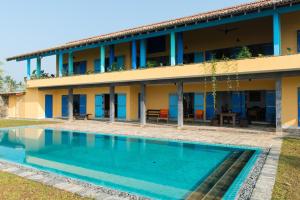 a building with a swimming pool in front of a building at Villa Atulya at Ocean's edge in Mirissa