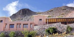 伊魯亞的住宿－Hotel Iruya，岩石山前的粉红色建筑