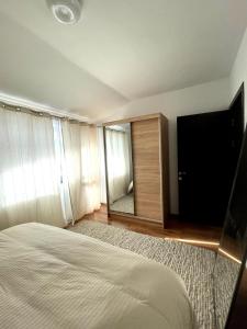 a bedroom with a bed and a large mirror at Tryavna Lake Apartment in Tryavna