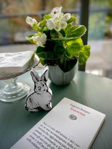 a pin of a rabbit on a table with a vase of flowers at Attico&Nuvole in Turin +79 photos