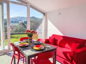 a living room with a red couch and a table at Holiday Home Villa Milu by Interhome in Imperia
