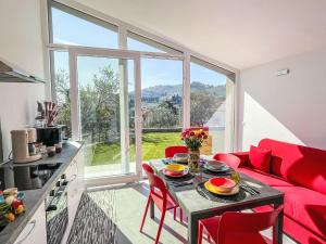 a living room with a red couch and a table at Holiday Home Villa Milu by Interhome in Imperia +49 photos