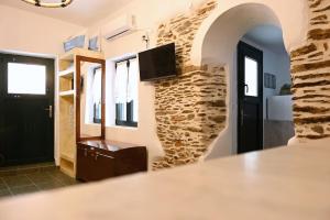 a room with a stone wall and a black door at House on the island in Kithnos