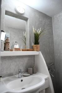a bathroom with a white sink and a mirror at House on the island in Kithnos +35 photos