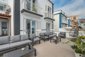 a patio with couches and chairs on a building at Villa Atlantico in Candelaria