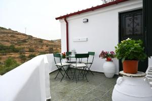 a patio with a table and chairs on a white house at House on the island in Kithnos