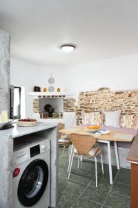 a kitchen with a washing machine and a table at House on the island in Kithnos