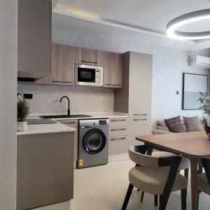une cuisine avec une machine à laver et une table dans l'établissement RT LUXURY ONE BEDROOM DUPLEX At BELROSE PLACE, à Accra