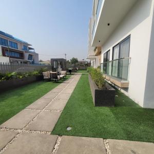 une cour d'un bâtiment avec de l'herbe verte dans l'établissement RT LUXURY ONE BEDROOM DUPLEX At BELROSE PLACE, à Accra