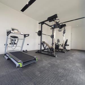 une salle de sport avec deux tapis de course et un tapis de course dans l'établissement RT LUXURY ONE BEDROOM DUPLEX At BELROSE PLACE, à Accra