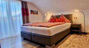 a bedroom with a bed with red pillows on it at Falkenstein - Ruhige familienfreundliche 3-Zimmer-Ferienwohnung mit Alpenpanorama in Pfronten Mitte in Pfronten