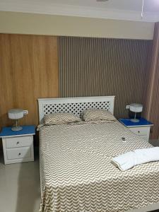 a bedroom with a white bed with two night stands at Boca chica retreat in Boca Chica