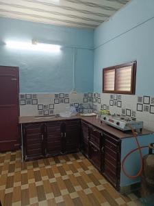 a kitchen with blue walls and a counter top at Bougainvilla in Alleppey