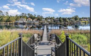 マートルビーチにあるPeaceful Retreat on the Intracoastal Waterway! Myrtle Beach - Indoor Poolの家並みのある湖上の木道