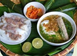 a plate of food with bowls of soup and vegetables at Cao Bang Clover House - Hotel & Motorbike Rentals in Cao Bằng