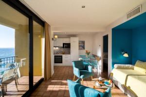 a living room with a bed and a living room with the ocean at La Résidence du Bailli in Rayol-Canadel-sur-Mer