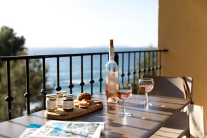 a table with a bottle of wine and two glasses at La Résidence du Bailli in Rayol-Canadel-sur-Mer