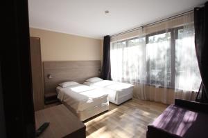 ein Hotelzimmer mit 2 Betten und einem großen Fenster in der Unterkunft Studio ApartCity in Braşov