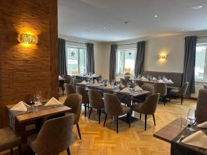 a restaurant with tables and chairs in a room at Hotel Haus am Ahorn in Schöneck