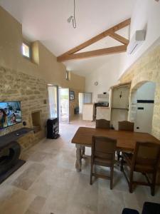 a living room with a wooden table and a fireplace at Village house near Uzes in Saint-Siffret