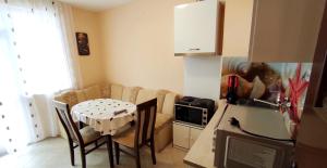 a kitchen with a table and chairs and a kitchen with a kitchen at Апартамент Сиракови Черноморец in Chernomorets