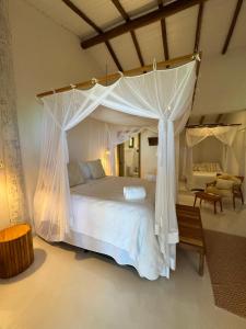 a bedroom with a white bed with a canopy at TRANCOSO - Casa Vista do Espelho in Porto Seguro +36 photos