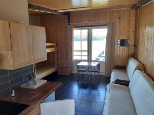 ein Wohnzimmer mit Sofa und Tisch in der Unterkunft Domki nad jeziorem i pod lasem in Zdbice