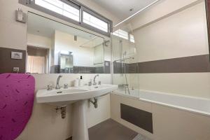 a bathroom with a sink and a mirror and a tub at Flexliving - room - Ternes in Paris