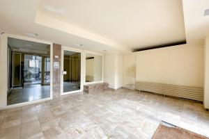 an empty room with a tile floor and large windows at Flexliving - room - Ternes in Paris