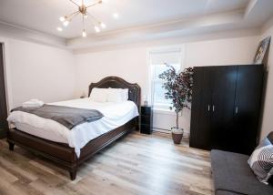 a bedroom with a large bed and a couch at Cozy One Bedroom Apartment- Downtown Moncton in Moncton