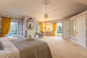 ハンマンビーにあるFamily friendly, big beautiful 17th Century houseの大きなベッドと黄色のカーテンのある広い寝室