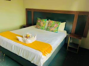 a bedroom with a bed with a white flower on it at Stay Inn Budget Rooms in Phalaborwa