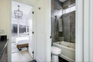 a bathroom with a toilet and a tub and a sink at The Luxury Black Rose Chalet at The Blue Mountains for 20 in Blue Mountains +60 photos