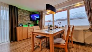 a dining room with a table and chairs and a tv at Eisenberg - Komfortables, helles Apartment mit Balkon und Alpenblick ruhig gelegen in Pfronten Mitte in Pfronten