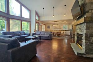 a living room with couches and a stone fireplace at All-Season 8BR Vacation Chalet in Blue Mountains