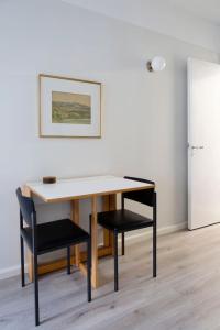 a table and two chairs in a room at Vintage Modern Apartment by Sea - Eiranranta in Helsinki