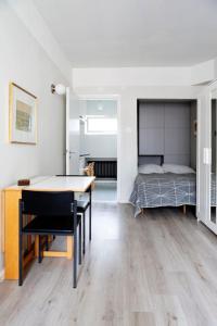 a living room with a dining room table and a bed at Vintage Modern Apartment by Sea - Eiranranta in Helsinki
