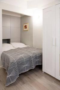 a bedroom with a bed with a gray blanket at Vintage Modern Apartment by Sea - Eiranranta in Helsinki