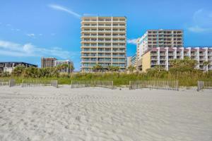 a beach with two tall buildings in the background at Oceanfront Oasis 1002 in Abbeyville